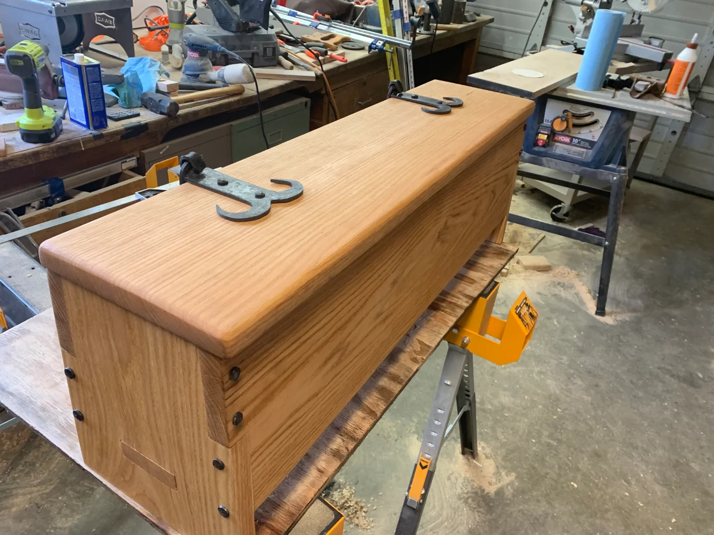 An oak chest on the bench, its forged hasps fitted